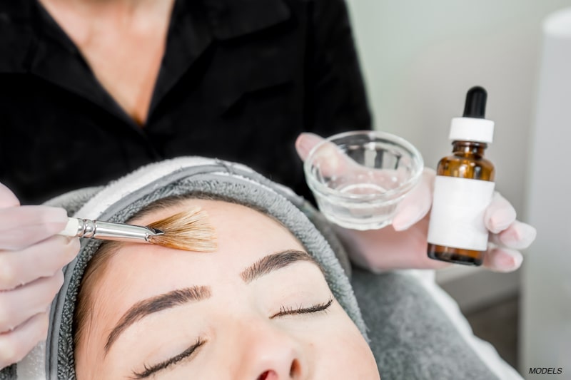 Woman getting a chemical peel on forehead.