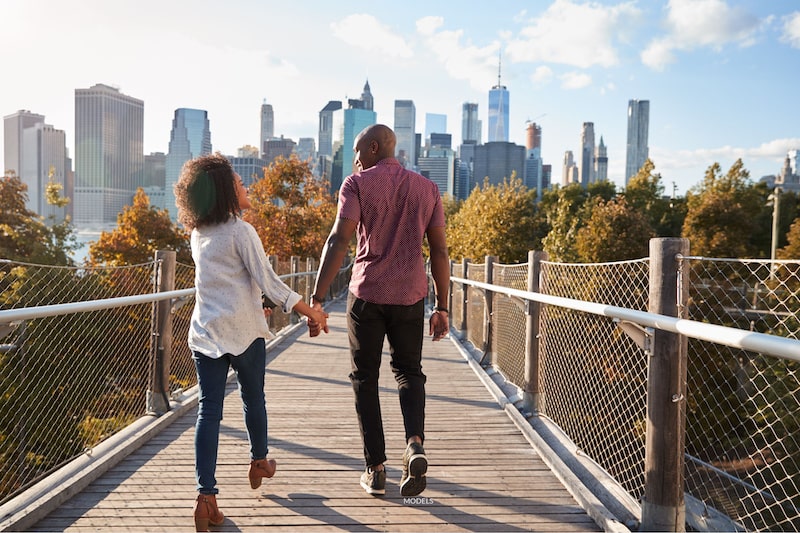 Couple walking across a bridge in New York City.
